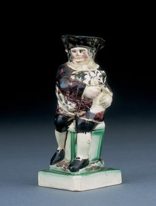 Dick Whittington jug, gemodelleerd zittend op een hoge stoel, zijn kat vasthoudend, gespat in bruine, groene en zwarte kleding, een gemodelleerd schild aan zijn zijde, c.1790