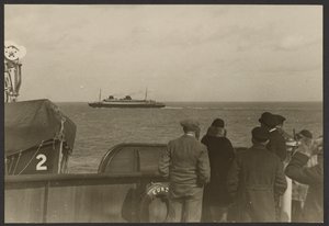 [Groep mensen op het dek van een schip die kijken naar een ander schip dat in de verte voorbij vaart]. door Erich Salomon