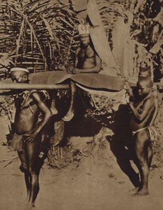 Hoofd van een Afrikaanse Pygmeeënstam wordt gedragen op een draagstoel (zw/w foto) door European Photographer