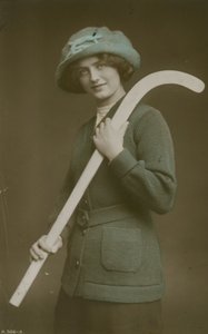 Jonge vrouw met een hockeystick over haar schouder