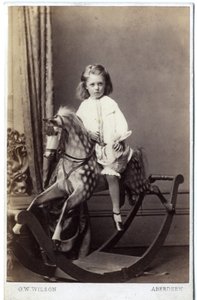 Jong meisje zittend op een schommelpaard door George Washington Wilson