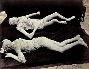 Twee afgietsels van menselijke figuren uit de opgravingen van Pompeii. De tentoonstellingen werden op zwart doek geplaatst om ze te fotograferen