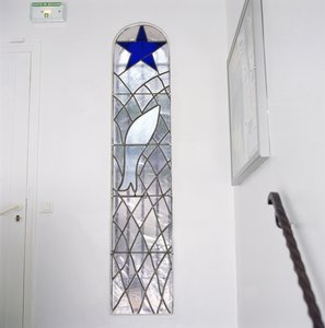 Glas-in-loodraam met een vis gevangen in een net onder de Ster des Heils, vanaf de trap naar de Rozenkranskapel