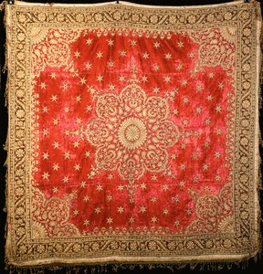 Een scharlaken fluwelen vloerkleed met groene fluwelen rand, dicht geborduurd met vergulde draad door Indian School