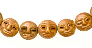 Een ketting gevonden rond de nek van de mummie met kleine gouden gezichten.