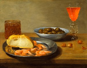 Een bord met garnalen en een rol en kom met olijven
