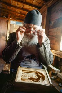 Een meesterbeeldhouwer en orthodoxe priester poseert met zijn werk. Berg Athos, Griekenland.