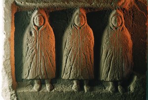 Een reliëfsculptuur die lokale godheden afbeeldt die tegen de kou zijn gehuld. Housesteads Romeins Fort.