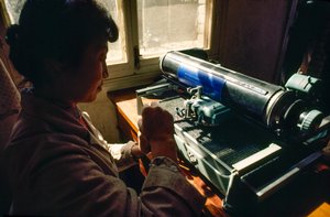 In het gemeentehuis typt een lid op een Chinese typemachine. Chun Xing Gemeente, Yunnan