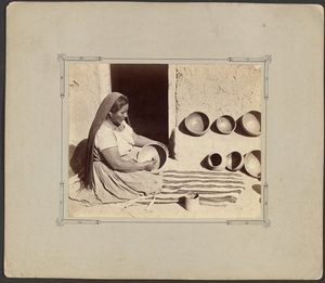 Vrouw die aardewerk poetst door John K. Hillers