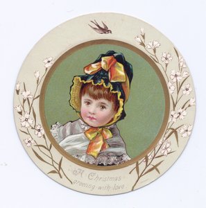 Victoriaanse wenskaart van een jongen met zijn arm om een meisje die naar een boek kijken, ca. 1880