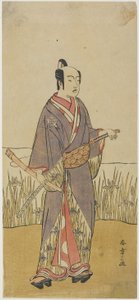 Een acteur in een samurai rol met een bamboefluit