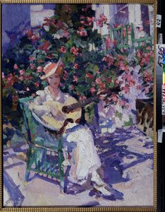 In de Krim. Een jonge vrouw in een lichte zomerjurk zit op een tuinstoel, voor een bloeiende struik, en speelt gitaar. door Konstantin Alekseevich Korovin