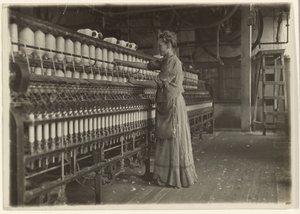 In een ouderwetse textielfabriek (spinner). door Lewis W. Hine