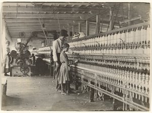 [Man met meisje bij spinmachine, Zuid-Carolina katoenfabriek]. door Lewis W. Hine
