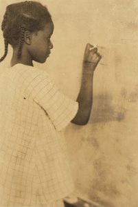 Jong meisje schrijft op schoolbord in klaslokaal, Pleasant Green School, Marlinton, Pocahontas County, West Virginia, VS ca. 1921 (sepia foto)