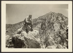 [Man bovenop rotsen]. door Louis Fleckenstein