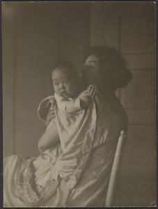 [Moeder die baby in stoel vasthoudt]