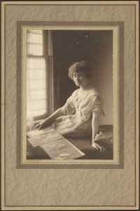 [Portret van een vrouw die naar een album kijkt]. door Louis Fleckenstein