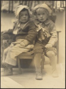 [Twee kinderen delen stoel]