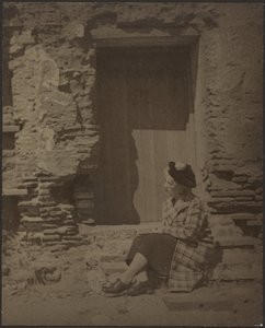 [Vrouw zit voor vervallen gebouw]. door Louis Fleckenstein