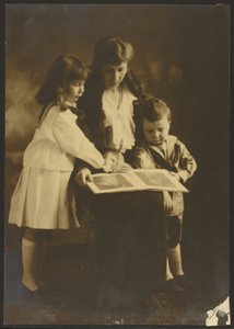 [Vrouw en kinderen met prentenboek]. door Louis Fleckenstein