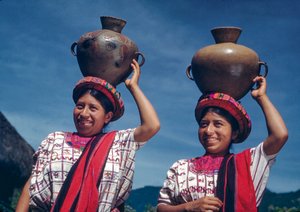Guatemalteekse vrouwen dragen waterkruiken in het dorp Nebaj, Guatemala