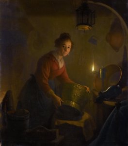 Vrouw in een keuken bij kaarslicht