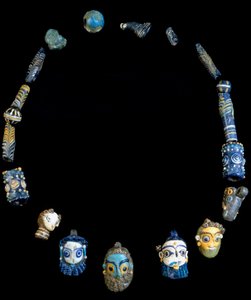 Ketting in glas pasta met hangers die bebaarde hoofden afbeelden, oorspronkelijk uit Olbia, nu bewaard in het Nationaal Archeologisch Museum van Cagliari
