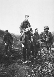 Een Duitse infanteriesoldaat met een gewonde been wordt van het slagveld gedragen door Engelse krijgsgevangenen