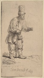 Een boer met een hoge muts, staand en leunend op een stok door Rembrandt van Rijn