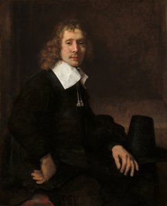 Een jonge man zittend aan een tafel mogelijk Govaert Flinck door Rembrandt van Rijn