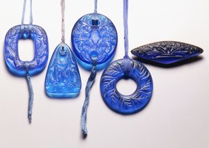 Vier turquoise glazen hangers en een verguld metalen gemonteerde glazen broche door Rene Jules Lalique
