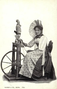 Vrouw zittend bij een spinnewiel