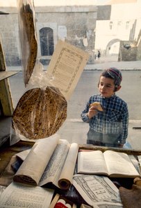 Conservatieve Joodse jongen eet cake en kijkt in een religieuze boekwinkel