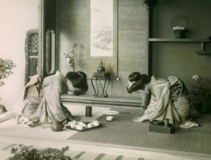 Twee Japanse vrouwen in traditionele klederdracht begroeten elkaar voor de theeceremonie, circa 1900 - 1915 (foto) door Teijiro Takagi