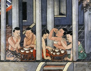 Mensen eten aan lage ronde tafels genaamd Kantoke, midden 19e eeuw door Thai School