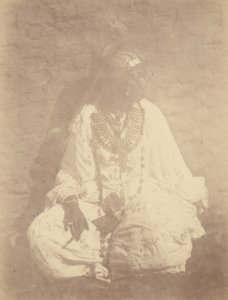 [Portret van een Noord-Afrikaanse vrouw zittend tegen een muur].