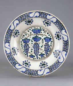 Een Iznik aardewerkschotel, met een centraal rondel met drie trossen druiven en wijnbladeren, ca.1570