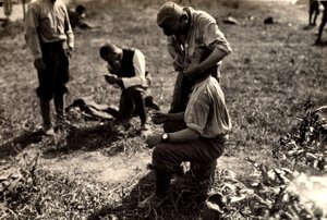 Oostenrijkse gevangenen tijdens de Eerste Wereldoorlog in Bagnaria Arsa, Udine, Italië; op de voorgrond scheert een soldaat een mede-soldaat, 02/04/1916