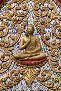 20151102, Vang Vieng, Laos: Ingangsdeur versierd met gouden reliëfs. De Onderwijzende Boeddha toont een bijzonder moment in het leven van de Boeddha, namelijk de eerste preek die de Boeddha gaf na het bereiken van Verlichting door Unbekannt