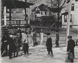 Een groep jongens in winterjassen die op een onbekende straat staan, voor of na een schooldag. door Unbekannt