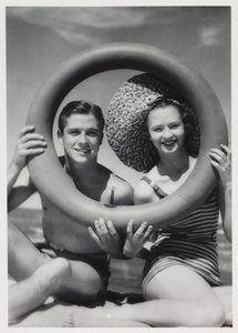 Man en vrouw die door een rubberen ring op het strand kijken, circa 1935 door Unbekannt