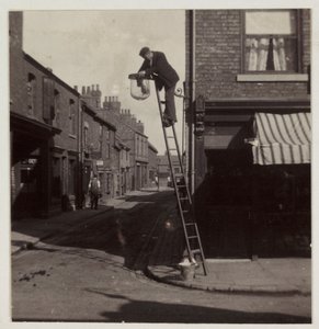 Man die een gaslantaarn schoonmaakt, ca. 1905