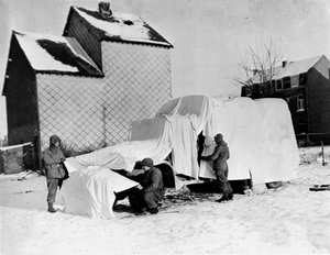 Tweede Wereldoorlog (1939-1945): In de buurt van Bastogne (België) eind december 1944: Deze Amerikaanse soldaten gebruiken witte lakens om een vrachtwagen te camoufleren voor de vijand door Unbekannt