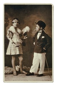Twee kinderen verkleed als volwassenen in de mode van de jaren 1920, het meisje draagt een outfit voor de Charleston, en hij in pak, bolhoed en sigaret. Fotografie door Unbekannter Künstler