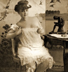 Jonge vrouw toont een kanten hemd, ca. 1900