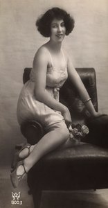 Een jonge vrouw poserend in haar onderjurk, zittend in een fauteuil door Unknown photographer