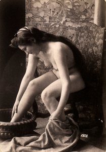 Portret van een naakte vrouw die haar voeten wast