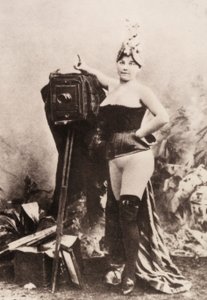 Portret van een gedeeltelijk naakte vrouw leunend op een antieke camera.